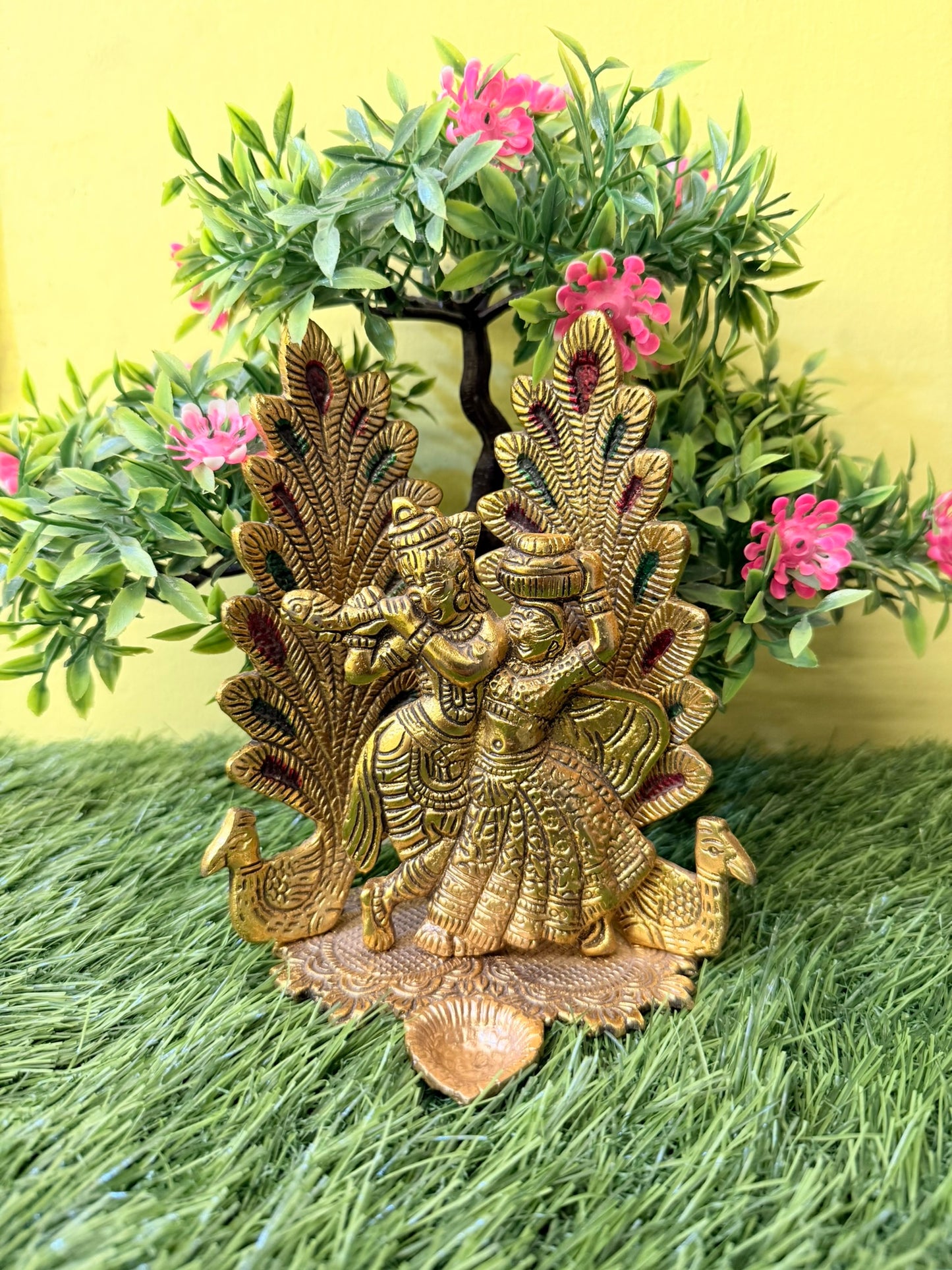 Peacock Design Radha Krishna Idol Showpiece with Diya. Ideal for Puja & Home Decor. Crafted in Metal with a Gold Finish. Size: 8x6 inches.